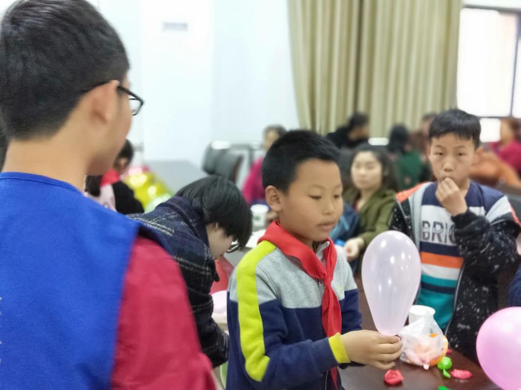 志愿者与小朋友一起布置活动场地